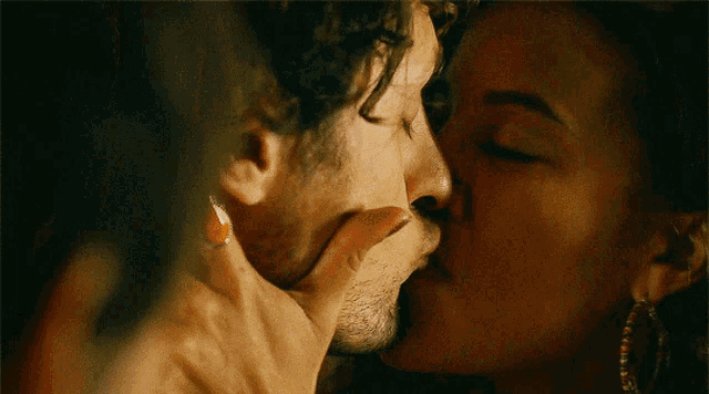a close up of a man and woman kissing