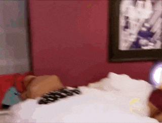 a blurry picture of a person laying on a bed in a bedroom .