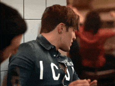 a man wearing a denim shirt with the word icons on it
