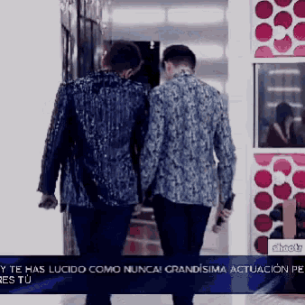two men walking in front of a sign that says y te has lucido como nunca