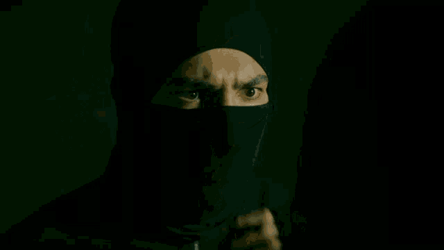a woman in a dark room looks at a man