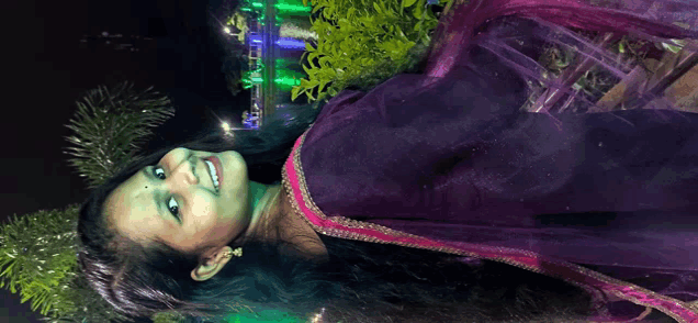 a woman in a purple dress is smiling with a green background