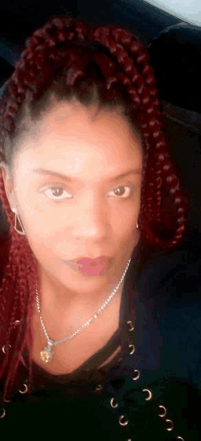 a woman with red braids looks at the camera