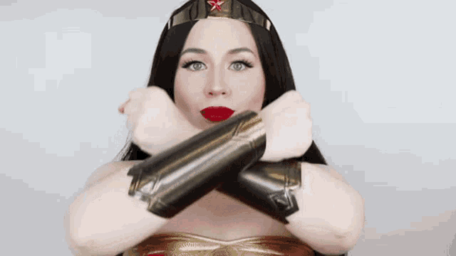a woman in a wonder woman costume is making a funny face while wearing wrist armor .