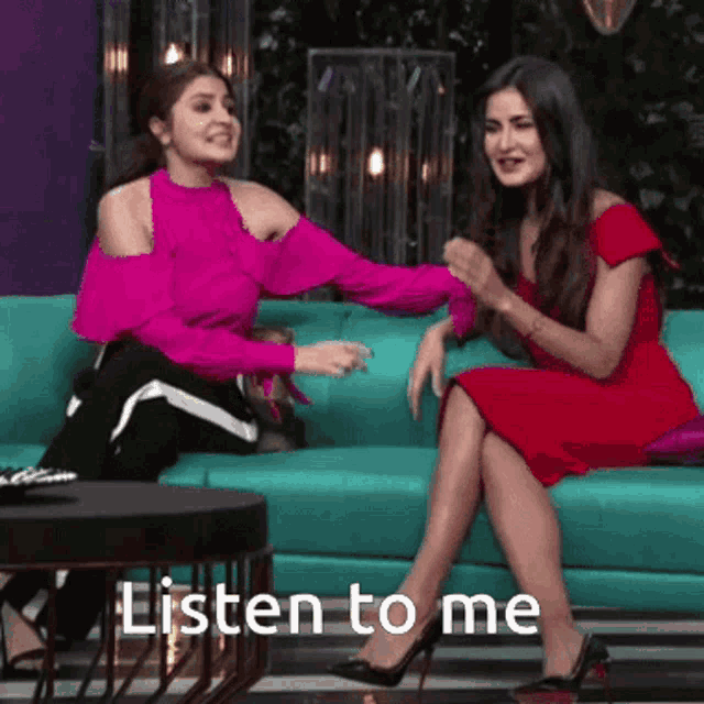 two women are sitting on a blue couch and the words listen to me are on the bottom