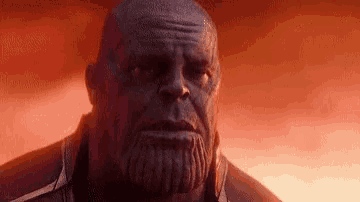 thanos from avengers infinity war is looking at the camera with a beard .