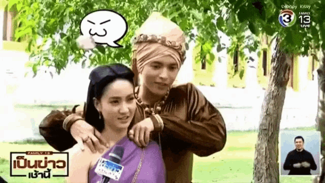 a man in a turban is hugging a woman in a purple dress in a park .