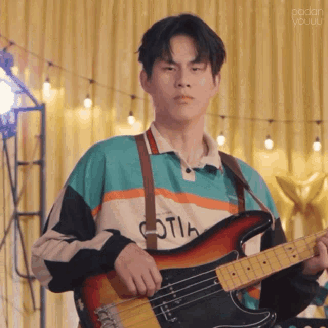 a young man playing a guitar with a shirt that says ' oth ' on it