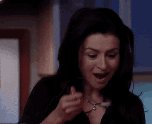 a woman is holding a piece of food in her hand and eating it .