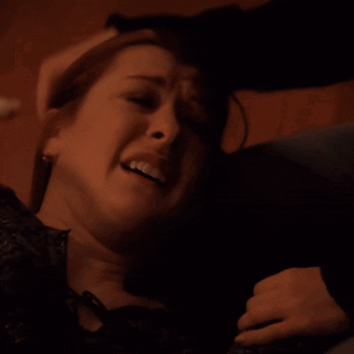 a close up of a woman 's face with a sad look on her face