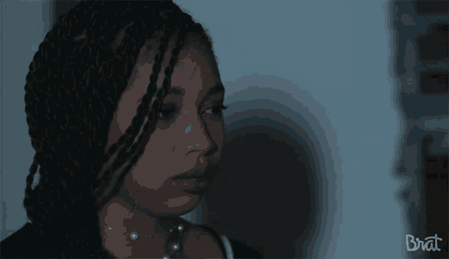 a close up of a woman 's face with the word brat on the bottom left