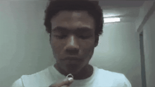 a man in a white t-shirt is holding something in his hand