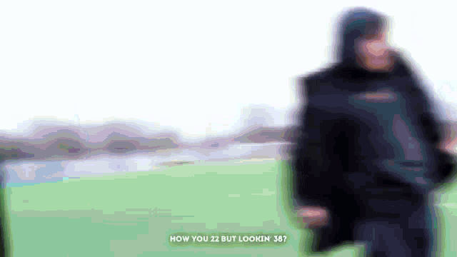 a blurry picture of a person standing on a field with the words how you 22 but lookin 36 on the bottom