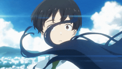 a boy with long black hair looks at the camera with a blue sky in the background