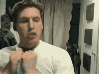 a man in a white shirt is tying a tie .