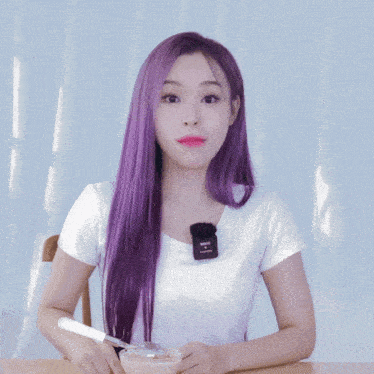 a woman with purple hair is sitting at a table