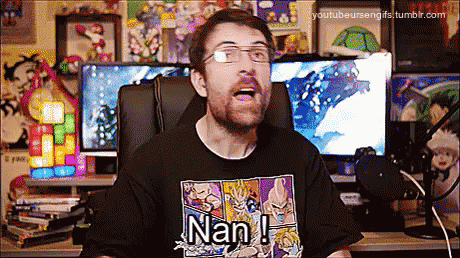 a man wearing a shirt that says nan is sitting in front of a computer