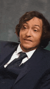 a man in a suit and tie is making a face