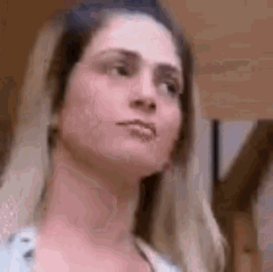 a close up of a woman 's face with a very serious look on her face .