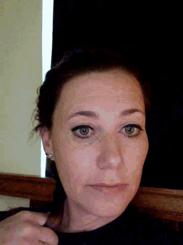 a close up of a woman 's face with a black background