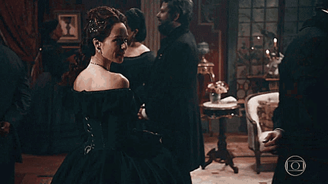 a woman in a green dress is dancing with a man in a tuxedo