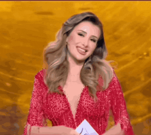 a woman in a red dress with a plunging neckline smiles
