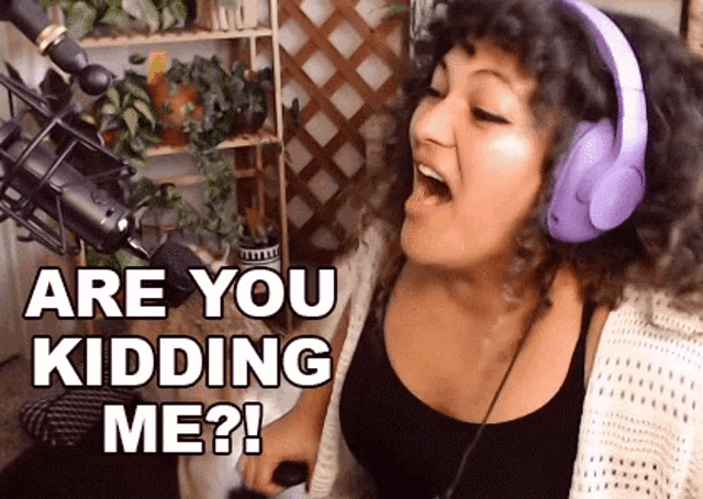 a woman wearing headphones is singing into a microphone .