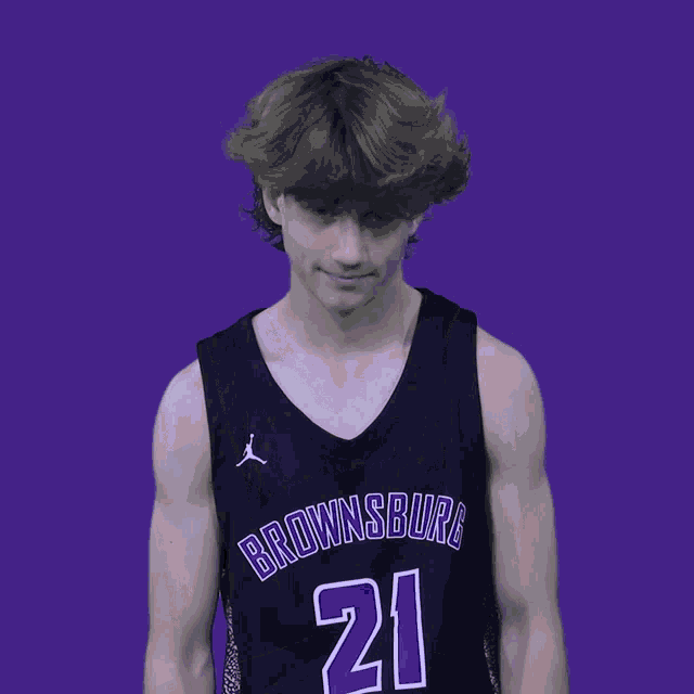 a young man wearing a black brownsburg jersey is clapping his hands
