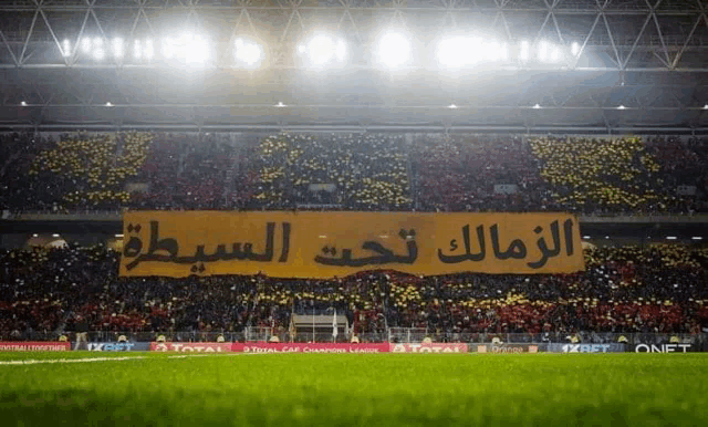 a soccer stadium with a banner that says total