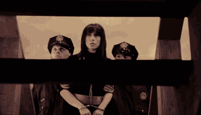 a woman in handcuffs is surrounded by police officers