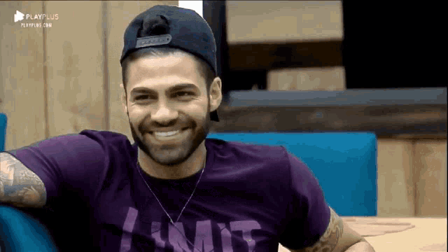 a man wearing a purple shirt that says limit smiles