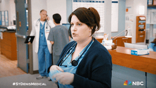 a woman with a stethoscope around her neck stands in front of a nbc ad