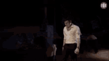 a man is kicking another man in the leg while a woman is laying on the floor .