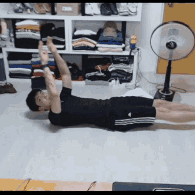 a man is laying on the floor with his arms up in the air
