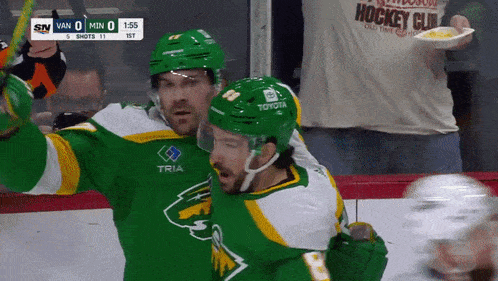 a hockey player wearing a green jersey that says tria