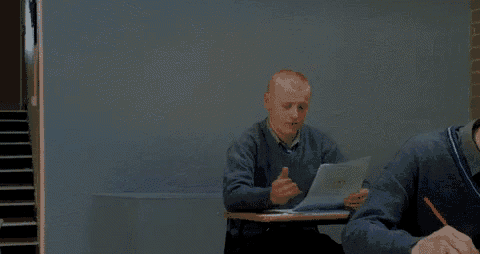 a man is sitting at a desk holding a piece of paper