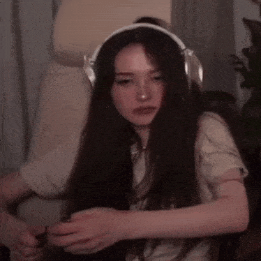 a woman wearing headphones is sitting in a chair holding a microphone .