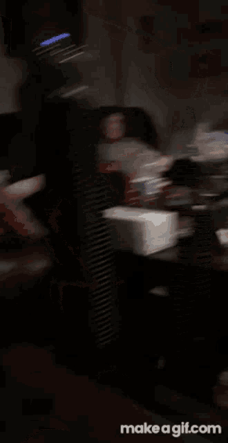 a blurry picture of a man sitting on a couch with a can of soda in the foreground .