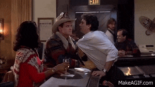 a man in a cowboy hat is talking to a woman in a bar