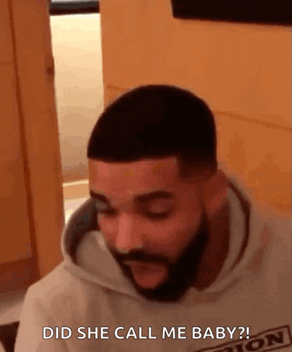 a man with a beard is sitting in a room and talking to someone .