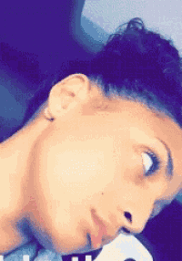 a close up of a woman 's face with her eyes closed and her tongue sticking out .