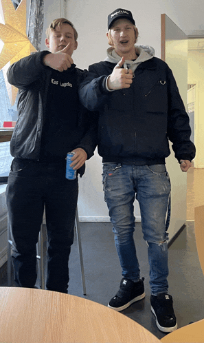 two young men are posing for a picture and one of them is wearing a shirt that says karl lager