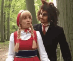 a woman in a red dress is standing next to a man in a suit and tie