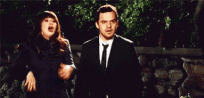 a man in a suit and tie is standing next to a woman in a black dress shouting .
