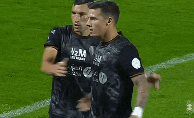 two soccer players are celebrating a goal and one has the number 7 on his shirt