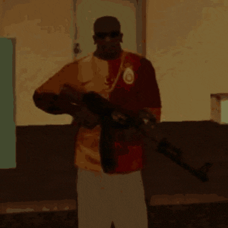 a man holding a gun wearing a shirt with the letter o on it