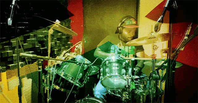 a man playing drums with a hat that says supreme