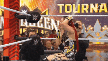 a woman in a wrestling ring with a sign that says tourney