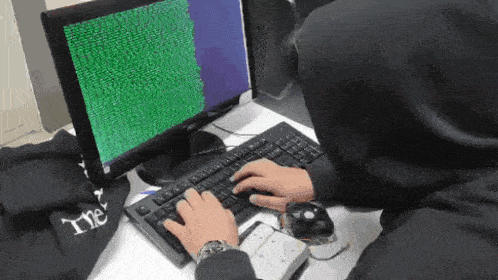 a person is typing on a keyboard in front of a computer screen that says " the "