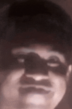 a close up of a person 's face with a shadow of a person on it .